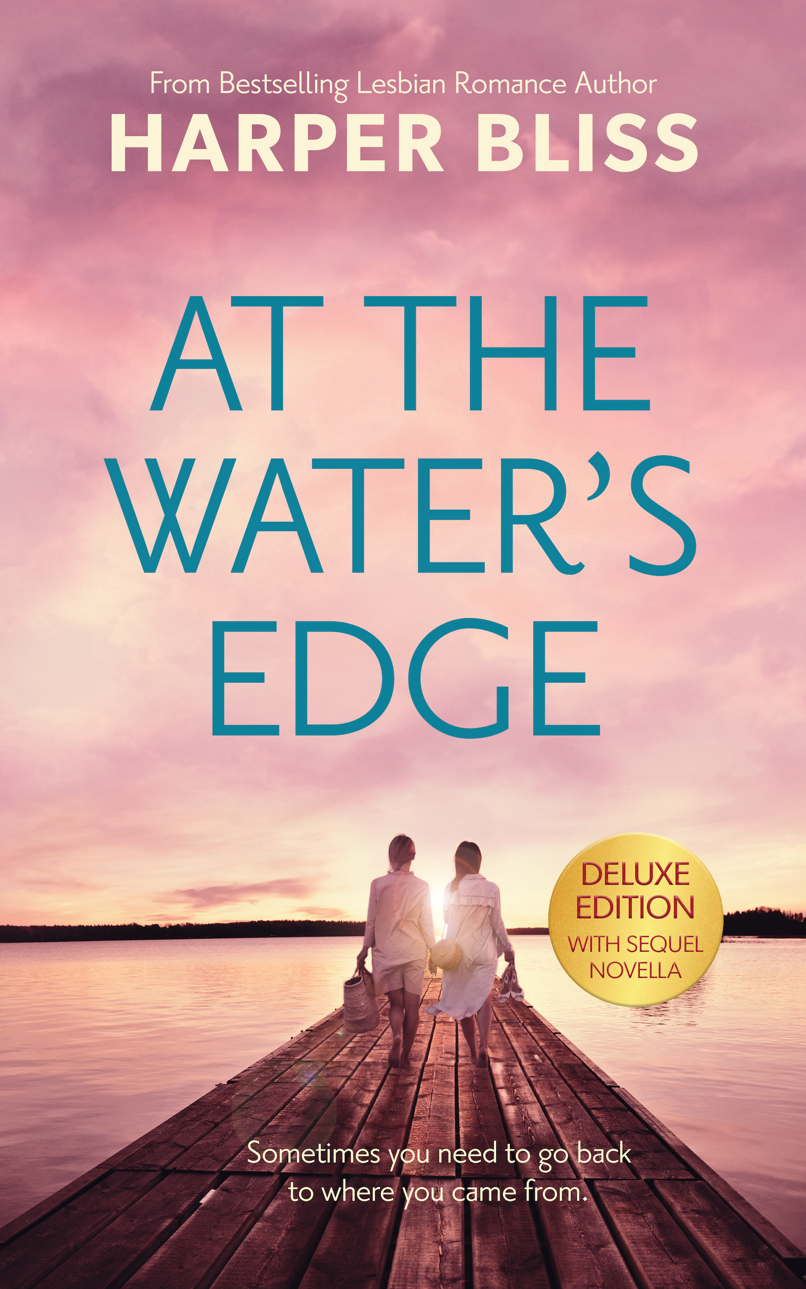 Book cover of At the Water’s Edge by Harper Bliss, featuring two women walking hand in hand on a wooden dock at sunset, with a serene lake and pink-hued sky in the background. The tagline reads, 'Sometimes you need to go back to where you came from.